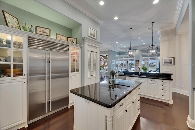 kitchen featuring stainless steel built in fridge, a sink, recessed lighting, dark wood-type flooring, and crown molding