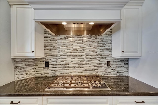 kitchen featuring stainless steel gas stovetop, decorative backsplash, and white cabinets