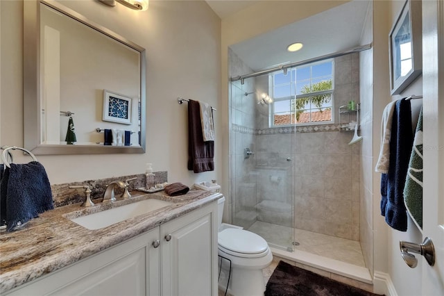 bathroom featuring a stall shower, toilet, and vanity