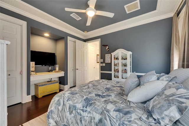 bedroom with wood finished floors, crown molding, ceiling fan, and baseboards