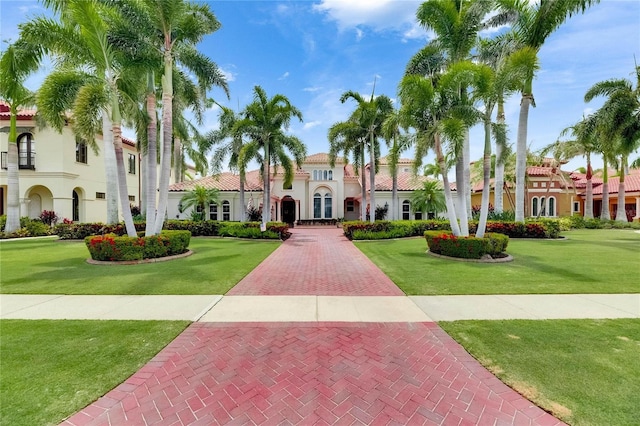 view of front of property featuring stucco siding, a front lawn, a tiled roof, and french doors