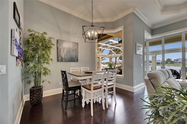 dining room featuring plenty of natural light, dark wood-style flooring, baseboards, a chandelier, and ornamental molding