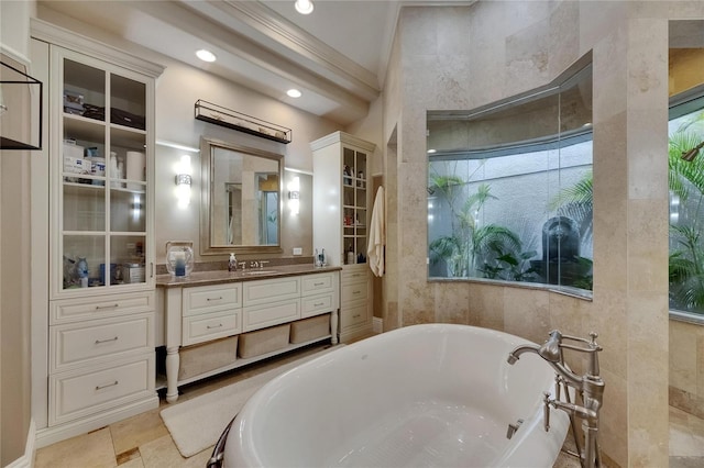 bathroom with a soaking tub, vanity, ornamental molding, and recessed lighting