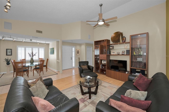3079 Landmark Blvd Unit 1608, Palm Harbor, FL 34684 - living area featuring a ceiling fan, light wood-style floors, a textured ceiling, vaulted ceiling, and baseboards