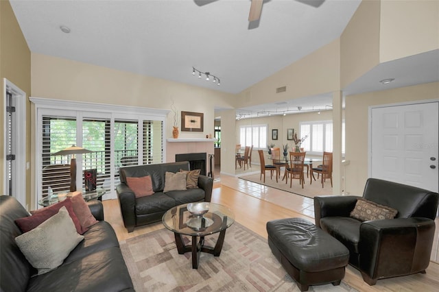 3079 Landmark Blvd Unit 1608, Palm Harbor, FL 34684 - living area with light wood-type flooring, ceiling fan, vaulted ceiling, a fireplace, and rail lighting