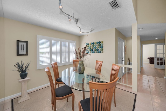 3079 Landmark Blvd Unit 1608, Palm Harbor, FL 34684 - tiled dining room with a textured ceiling, baseboards, and rail lighting