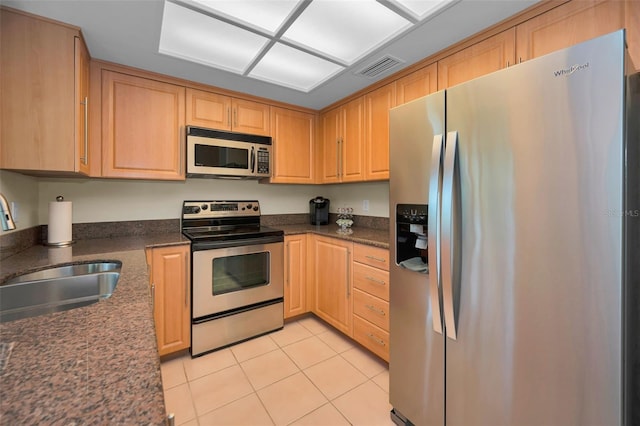 3079 Landmark Blvd Unit 1608, Palm Harbor, FL 34684 - kitchen with stainless steel appliances, a sink, light tile patterned flooring, light brown cabinetry, and dark stone countertops
