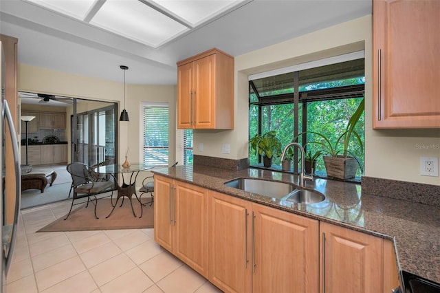 3079 Landmark Blvd Unit 1608, Palm Harbor, FL 34684 - kitchen featuring a sink, dark stone counters, a ceiling fan, light tile patterned floors, and pendant lighting