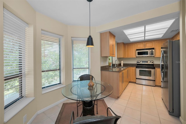 3079 Landmark Blvd Unit 1608, Palm Harbor, FL 34684 - kitchen featuring appliances with stainless steel finishes, a sink, dark countertops, light tile patterned flooring, and pendant lighting