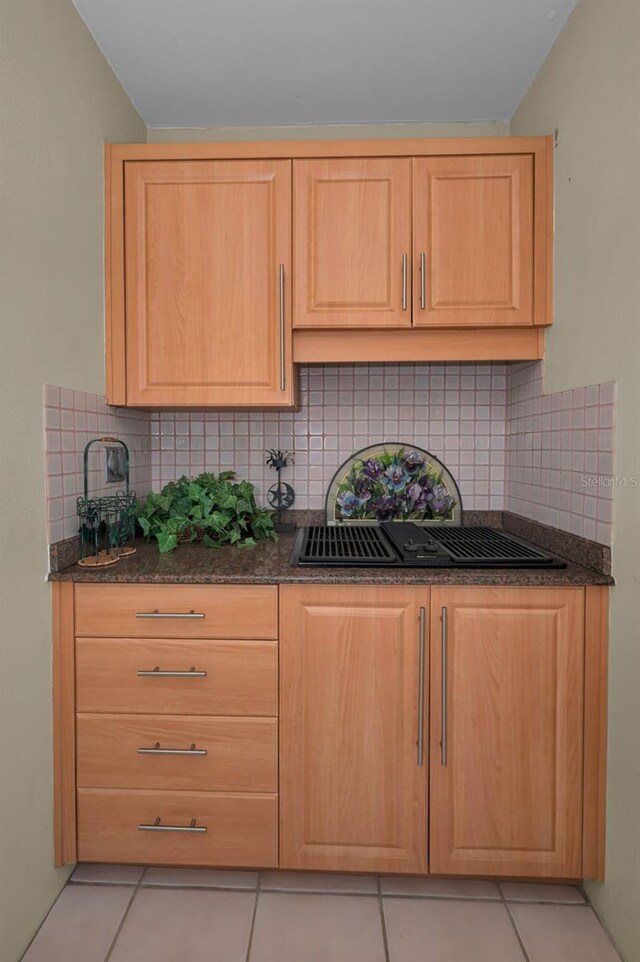 3079 Landmark Blvd Unit 1608, Palm Harbor, FL 34684 - kitchen featuring light brown cabinets, light tile patterned floors, decorative backsplash, and dark stone countertops