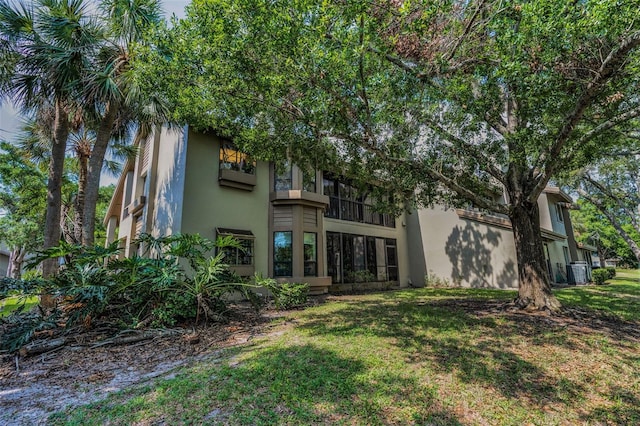 3079 Landmark Blvd Unit 1608, Palm Harbor, FL 34684 - back of house with central AC, stucco siding, and a yard