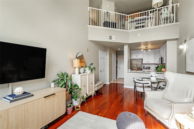 living room with wood finished floors, a high ceiling, and baseboards