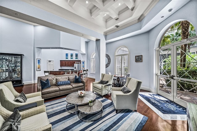 living area featuring a high ceiling, dark wood-style floors, beam ceiling, baseboards, and coffered ceiling