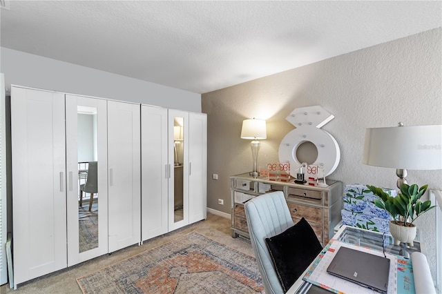 office area with carpet floors, a textured wall, and a textured ceiling
