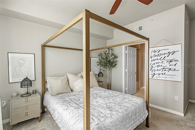 bedroom featuring light colored carpet, baseboards, and a ceiling fan