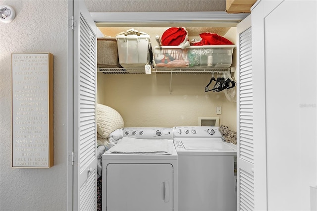 washroom with a textured wall and washer and clothes dryer