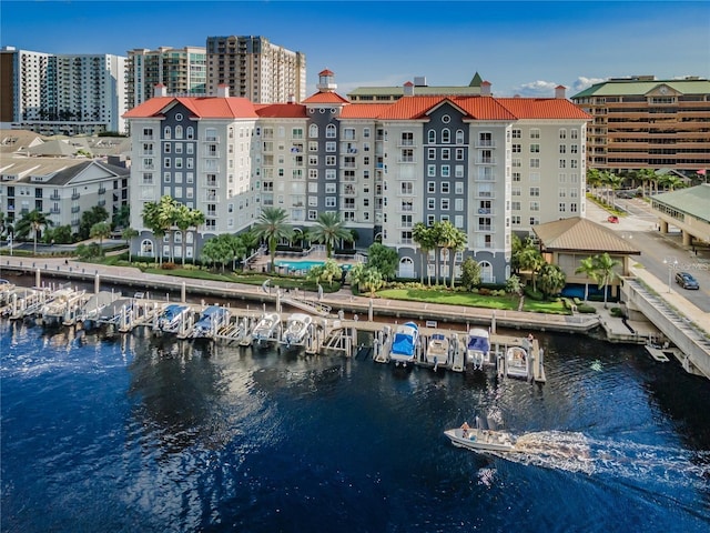 view of building exterior featuring a water view, view of marina, and a view of city