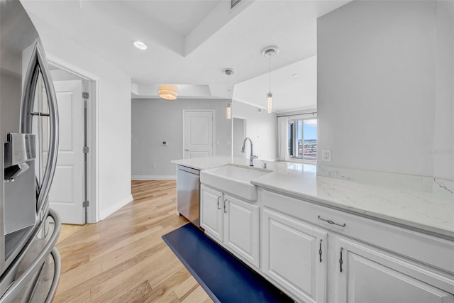 kitchen with baseboards, a sink, white cabinetry, light wood-style floors, and appliances with stainless steel finishes
