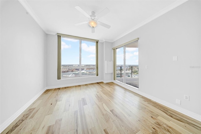 spare room with light wood finished floors, crown molding, baseboards, and ceiling fan