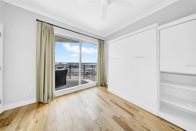 spare room with baseboards, light wood finished floors, and ceiling fan