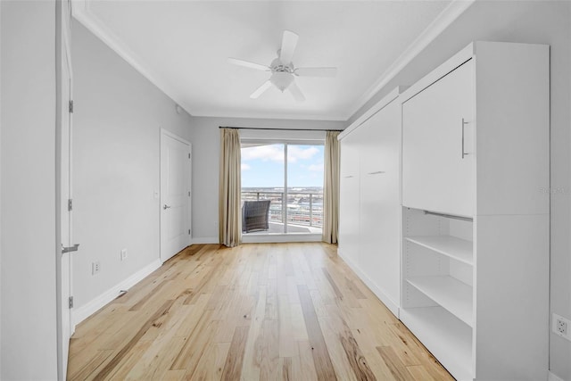 interior space featuring access to exterior, light wood-type flooring, baseboards, ceiling fan, and ornamental molding