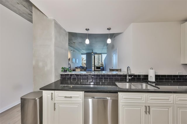 bar with a sink, light wood-type flooring, stainless steel dishwasher, and decorative light fixtures