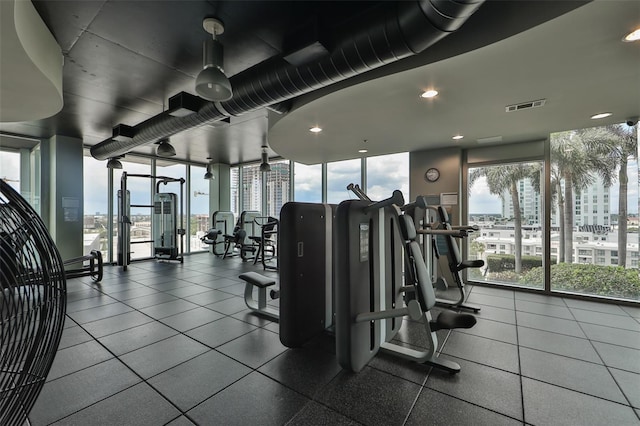 workout area featuring visible vents, a view of city, a healthy amount of sunlight, and recessed lighting