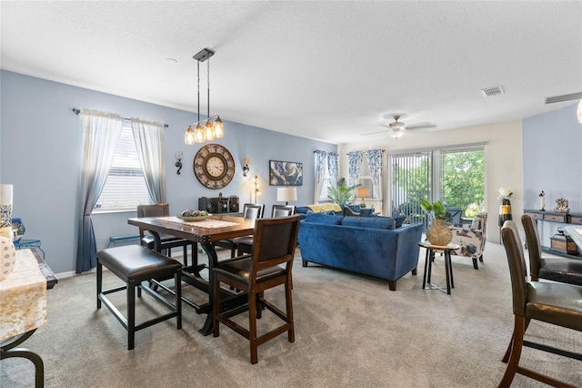 10626 Laguna Plains Dr, Riverview, FL 33578 - dining area with light colored carpet, a textured ceiling, and a ceiling fan