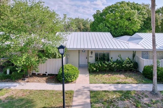 11473 W Sandpiper Ct, Crystal River, FL 34429 - view of front facade with fence, stucco siding, metal roof, and a standing seam roof