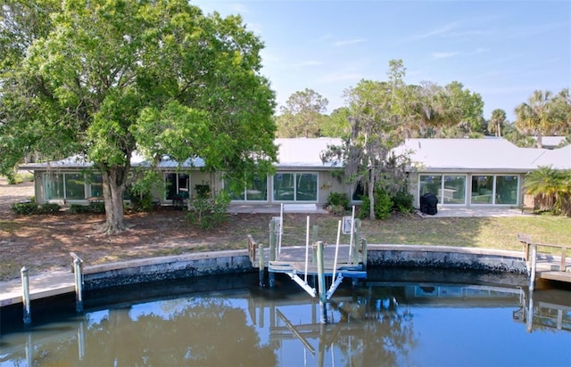 11473 W Sandpiper Ct, Crystal River, FL 34429 - back of house featuring boat lift, a water view, and a lawn