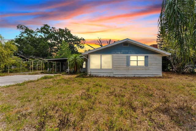 exterior space featuring a chimney, an attached carport, and aphalt driveway