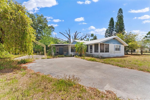 ranch-style home with a sunroom and aphalt driveway