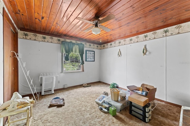 unfurnished room featuring a ceiling fan, baseboards, carpet flooring, and wood ceiling