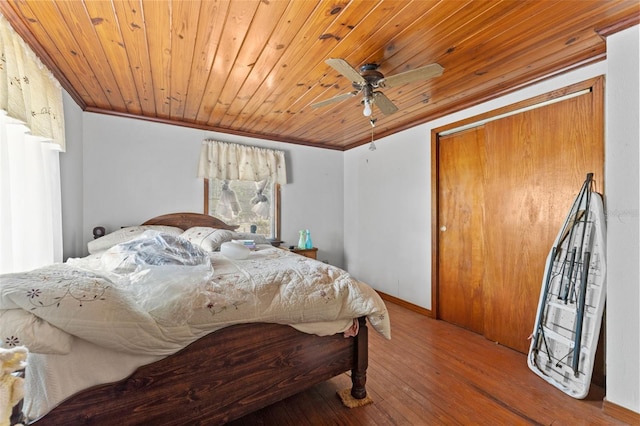 bedroom featuring crown molding, wooden ceiling, a ceiling fan, and hardwood / wood-style floors