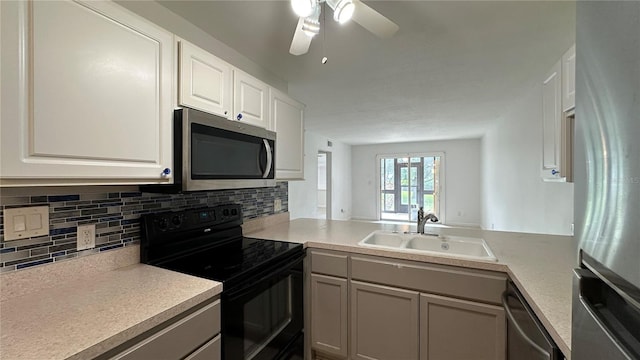 kitchen featuring a sink, stainless steel appliances, ceiling fan, light countertops, and tasteful backsplash