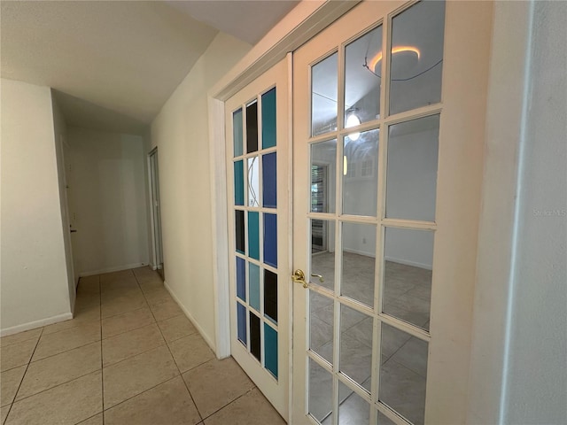 corridor with baseboards, french doors, and tile patterned floors