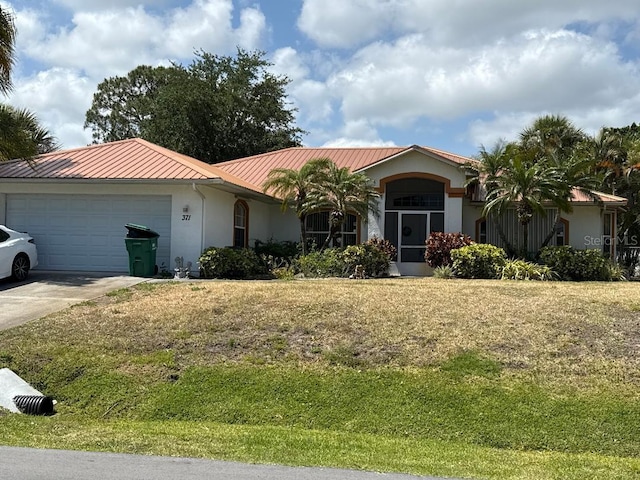371 Faith Ter, Sebastian, FL 32958 - mediterranean / spanish house featuring a standing seam roof, metal roof, a garage, stucco siding, and concrete driveway