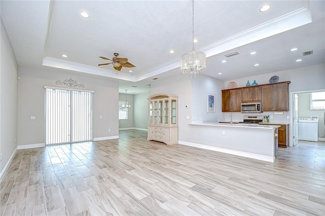 5732 Stockport St, Riverview, FL 33578 - kitchen featuring ceiling fan with notable chandelier, open floor plan, a raised ceiling, appliances with stainless steel finishes, and ornamental molding