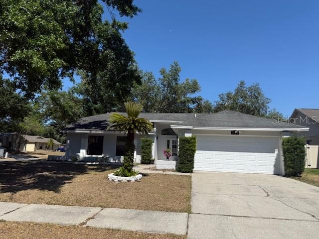 1710 Tallowtree Cir, Valrico, FL 33594 - ranch-style house with concrete driveway and an attached garage