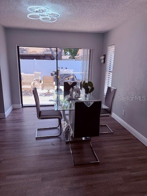 1710 Tallowtree Cir, Valrico, FL 33594 - dining room with baseboards, a textured ceiling, and wood finished floors