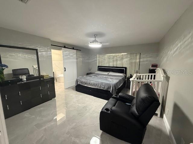1710 Tallowtree Cir, Valrico, FL 33594 - bedroom with a barn door and marble finish floor