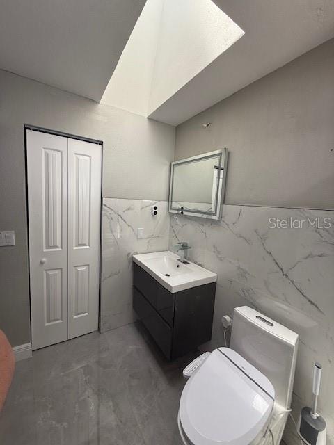 1710 Tallowtree Cir, Valrico, FL 33594 - half bathroom with vanity, toilet, tile walls, and concrete floors