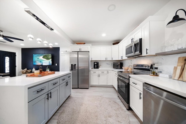 14 S Meteor Ave, Clearwater, FL 33765 - kitchen with stainless steel appliances, light countertops, a ceiling fan, white cabinets, and backsplash