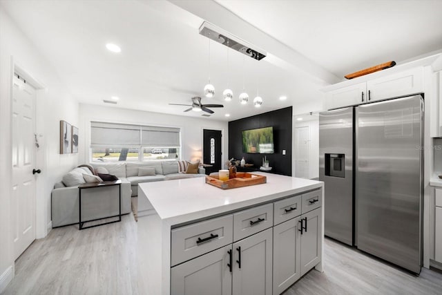 14 S Meteor Ave, Clearwater, FL 33765 - kitchen featuring stainless steel fridge, light wood finished floors, light countertops, a ceiling fan, and a kitchen island