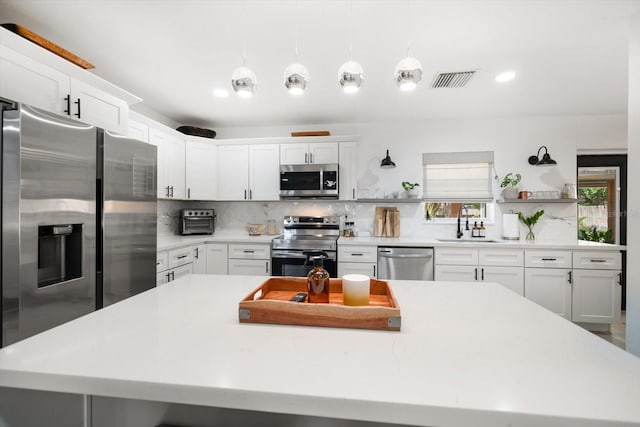 14 S Meteor Ave, Clearwater, FL 33765 - kitchen featuring stainless steel appliances, open shelves, a sink, a kitchen island, and backsplash