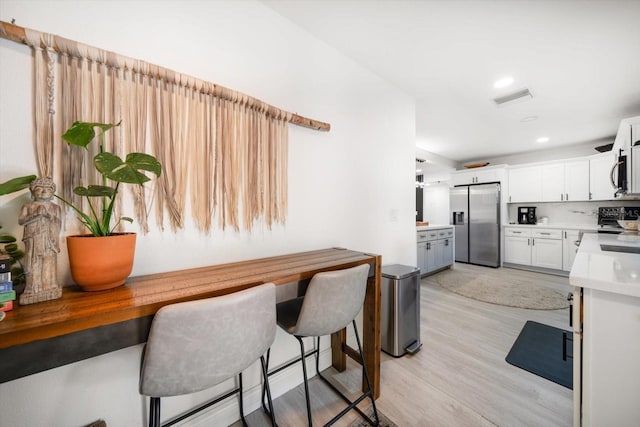 14 S Meteor Ave, Clearwater, FL 33765 - kitchen featuring appliances with stainless steel finishes, light wood-type flooring, white cabinetry, light countertops, and recessed lighting