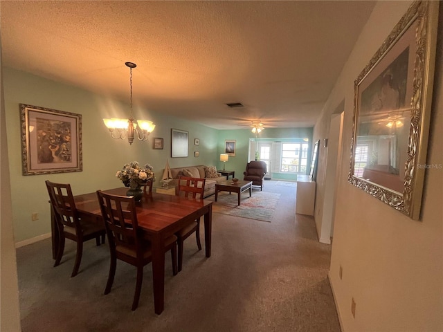 dining area with carpet floors, a chandelier, and a textured ceiling