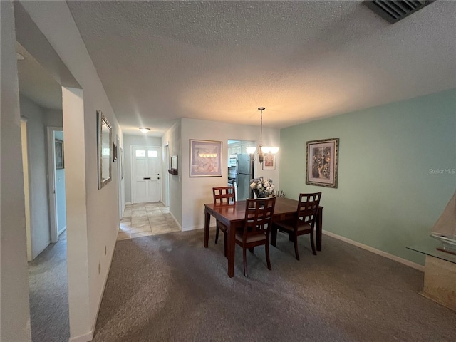 dining space with light colored carpet, a textured ceiling, baseboards, and a chandelier