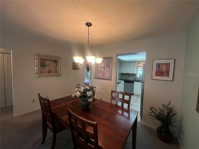 carpeted dining space featuring a chandelier, a textured ceiling, and baseboards