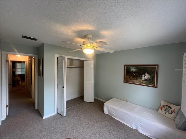 bedroom featuring a closet, carpet flooring, baseboards, ceiling fan, and a textured ceiling